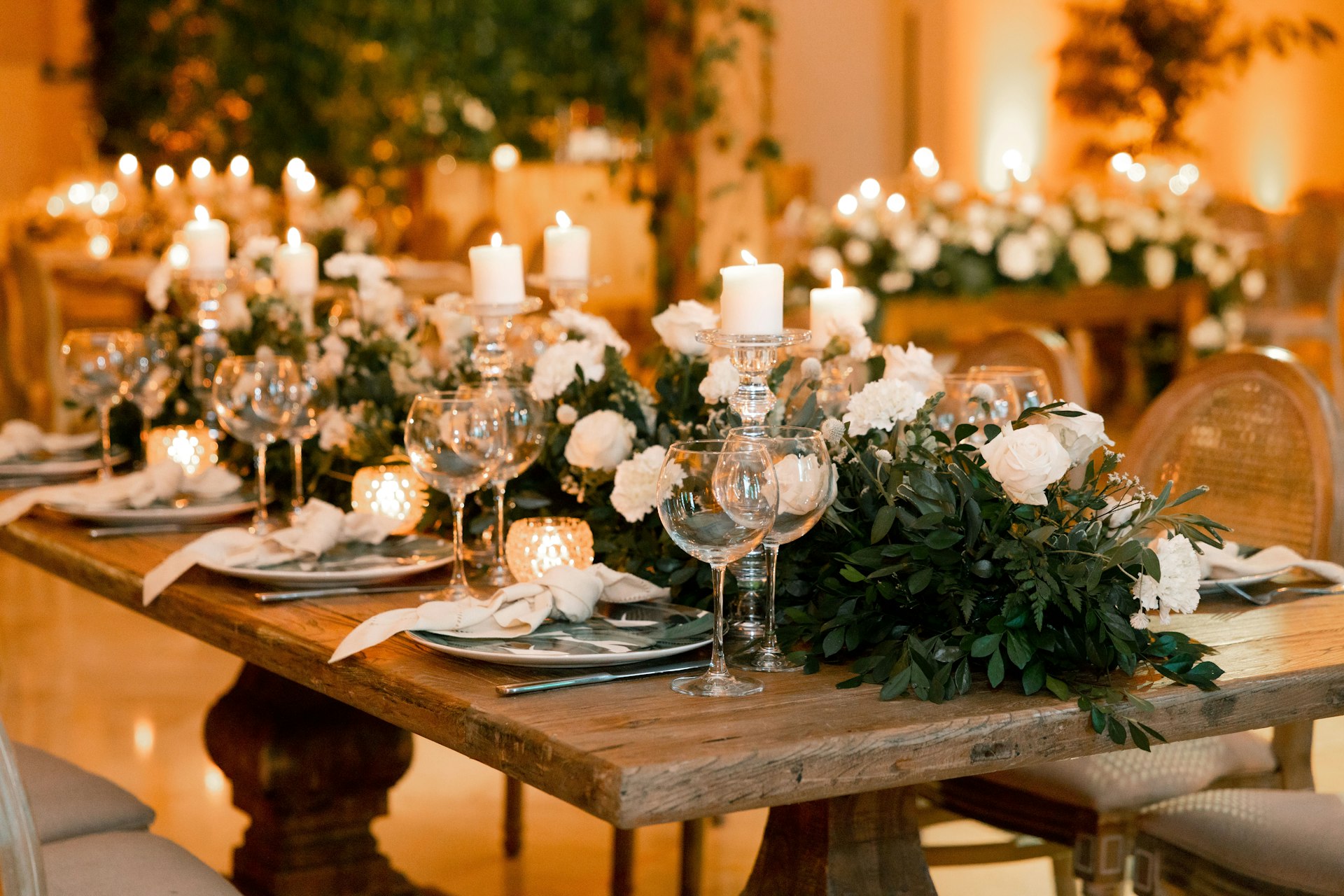 a table set for a formal dinner with candles and flowers